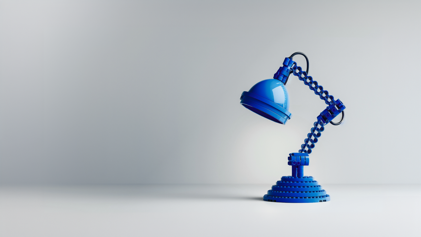 A blue articulated desk lamp sits on a flat surface against a plain background, illuminated from above.